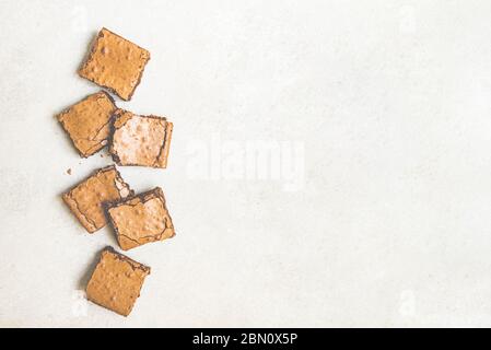 Draufsicht auf frisch gebackenen hausgemachten Brownie Kuchen in Quadraten über weißem rustikalen Hintergrund geschnitten. Kopierbereich. Stockfoto