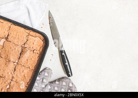 Draufsicht auf frisch gebackenen hausgemachten Brownie Kuchen in Quadraten über weißem rustikalen Hintergrund geschnitten. Kopierbereich. Stockfoto