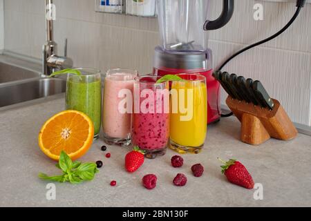 Bunte Smoothies in Glas mit frischem Obst auf dem Küchentischtisch Stockfoto
