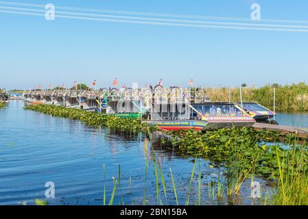 Everglades, Vereinigte Staaten von Amerika - 27. April 2019: Touristen-Airboats in schlanken Reihen vertäut erwartet Touristen in Everglades National Park, Florida. Stockfoto