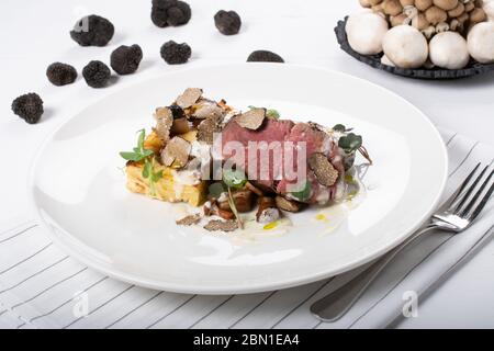 Trüffel duftenden Rindfleisch Tenderloin, lokale Trüffel, Gratin Kartoffeln, sautierten Wildpilzen, Käse-Sauce Stockfoto