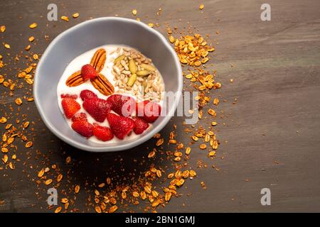 Gericht mit Joghurt, Erdbeeren, Müsli, Nüssen, ideal für eine energiegeladene vegetarische Ernährung Stockfoto