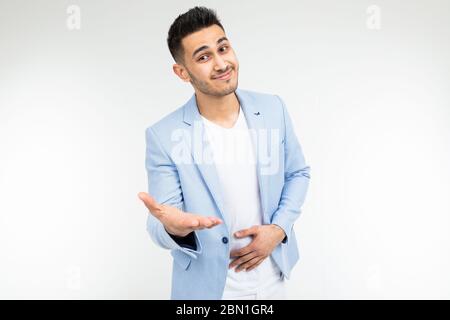 Business-Mann in einer blauen klassischen Jacke hält seine Hände auf einem weißen Hintergrund mit Copy-Raum. Stockfoto