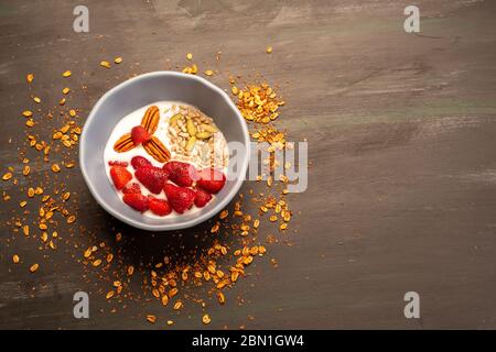 Gericht mit Joghurt, Erdbeeren, Müsli, Nüssen, ideal für eine energiegeladene vegetarische Ernährung Stockfoto