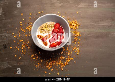 Gericht mit Joghurt, Erdbeeren, Müsli, Nüssen, ideal für eine energiegeladene vegetarische Ernährung Stockfoto
