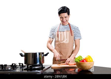 Asian Mann schneiden Gemüse mit einem Messer auf Schneidebrett isoliert über weißem Hintergrund Stockfoto