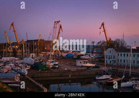 Schöne bunte Sonnenuntergang Hafengebiet mit Portalkrane, Yachten und Boote in Klaipeda, Litauen. Stockfoto