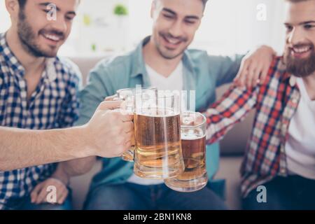 Prost! Nahaufnahme, ein Foto von glücklichen, gutaussehenden Männern, die den Sieg feiern und ein Glas Bier anklirren. Sie sind Fans von Sportspielen wie Fußball Stockfoto