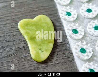 Gua Sha Werkzeug aus Naturstein aus grüner Jade mit Akupressur Matte. Alternative Medizin und Selbstmassage zu Hause Massage Konzept Stockfoto