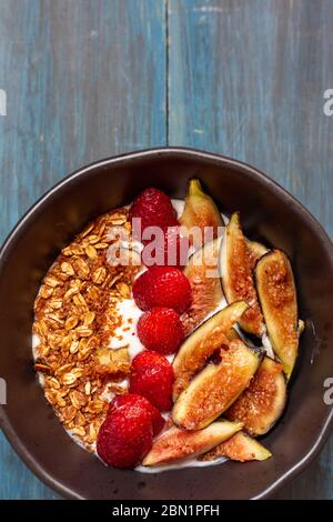 Gericht mit Joghurt, Erdbeeren, Müsli, Nüssen, ideal für eine energiegeladene vegetarische Ernährung Stockfoto
