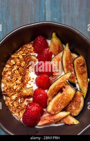 Gericht mit Joghurt, Erdbeeren, Müsli, Nüssen, ideal für eine energiegeladene vegetarische Ernährung Stockfoto