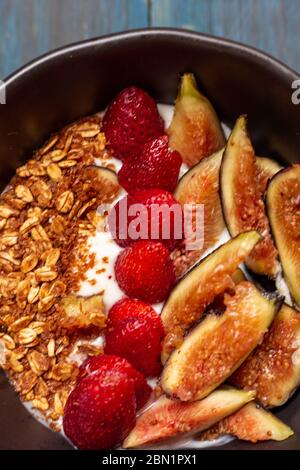 Gericht mit Joghurt, Erdbeeren, Müsli, Nüssen, ideal für eine energiegeladene vegetarische Ernährung Stockfoto