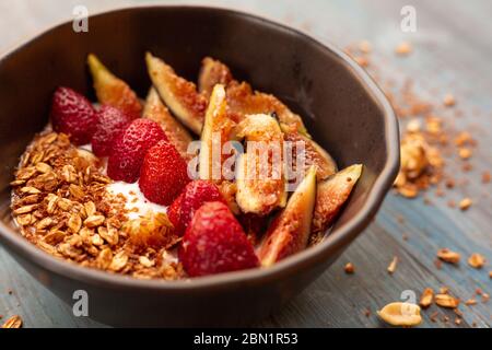 Gericht mit Joghurt, Erdbeeren, Müsli, Nüssen, ideal für eine energiegeladene vegetarische Ernährung Stockfoto