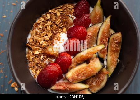 Gericht mit Joghurt, Erdbeeren, Müsli, Nüssen, ideal für eine energiegeladene vegetarische Ernährung Stockfoto