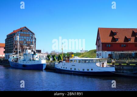 Bootsanlegestelle für Boote und Yachten in Klaipeda, Litauen, an sonnigen Tagen. Schöne Sicht auf Schiffe und das Fachwerk und die roten Backsteinhäuser Stockfoto