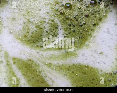 Nahaufnahme eines Matcha Latte Schaum voller kleiner Blasen Stockfoto