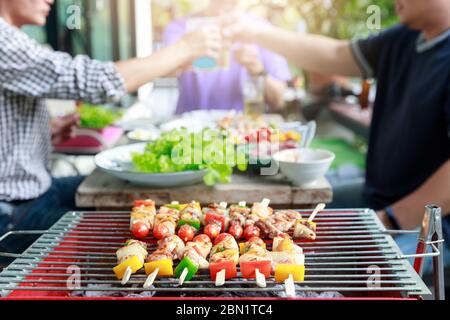 Freunde, die Party machen und Barbecue in Gardern kochen. Stockfoto