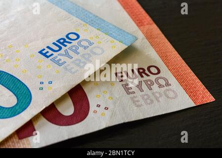 Makrofotografie des Wortes Euro auf zwei Euro-Banknoten auf schwarzem Hintergrund. Geld, Einkommen und Ausgaben, Stand des Wirtschaftskonzepts. Nahaufnahme. Stockfoto