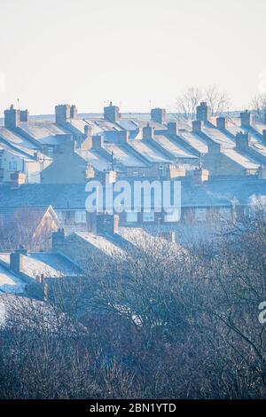 Reihen von Reihenhäusern an einem nebelkalten Wintermorgen, in Consett, Grafschaft Durham, Großbritannien Stockfoto