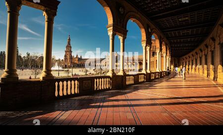 Sevilla, Spanien - 17. Februar 2020 - Spanien Platz / Plaza de Espana mit schöner Aussicht auf den Nordturm durch die Säulen mit Architektur Det Stockfoto