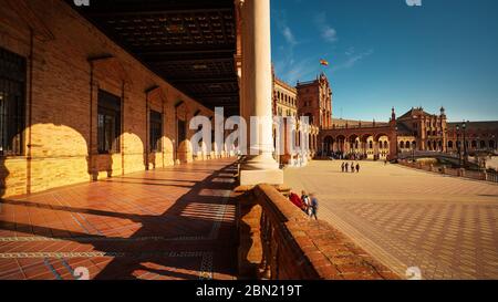 Sevilla, Spanien - 18. Februar 2020 - Sevilla Plaza de Espana / Spanien Platz mit schöner Aussicht auf die Korridore und Säulen des Königspalastes und die Touris Stockfoto