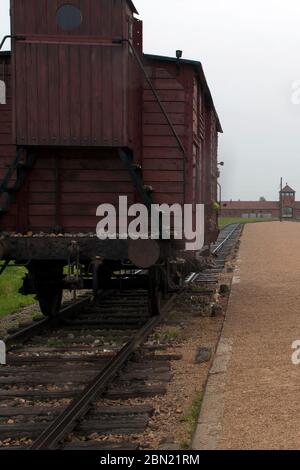 Holocaust-Gedenkmuseum Auschwitz - Ansicht der Eisenbahnlinie mit Zugwaggon zum Stadthaus Auschwitz II-Birkenau in der Ferne Stockfoto