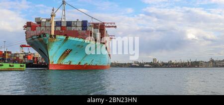 Containerfrachtschiffladung im Seehafen. Logistik und Transport von Container Cargo Schiff mit funktionstüchtigen Kranbrücke in der Werft, logistischer Import Stockfoto