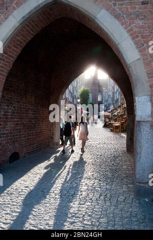 Danzig Polen, Blick auf die Altstadt durch den Torbogen mit langen Schatten am Nachmittag Stockfoto