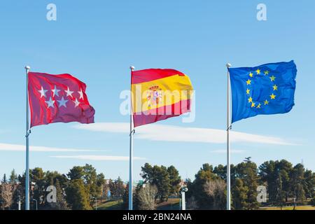 Madrid, Spanien und Europa EU-Flaggen auf Fahnenmasten vor dem Hintergrund des Himmels winken Stockfoto