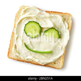 Geröstetes Brot mit Frischkäse und Gurken Gesicht isoliert auf weißem Hintergrund, Draufsicht Stockfoto