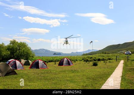 Kamtschatka Halbinsel, Russland - 8. Juli 2018: Hubschrauber landet in der Nähe des Zeltcampings im Kronotsky Reservat in der Nähe des Kurilen Sees Stockfoto