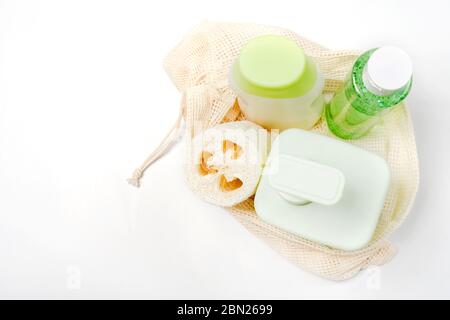 Verschiedene Behälter für Shampoo, Conditioner, Tonikum, Flüssigseife in Öko-Beutel. Lofah oder Luffa Waschlappen, Gemüseschwamm, Alternative zu Kunststoff Stockfoto