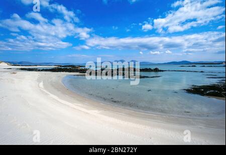 Leerer weißer Sandstrand in der Nähe des Strandes auf der Hebriden-Insel Colonsay im Sommer mit der Insel und den kleinen Jura am Horizont, Schottland, Großbritannien Stockfoto
