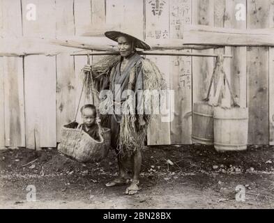 Japanischer Bauernmann, der Kind in einem Korb trägt Stockfoto