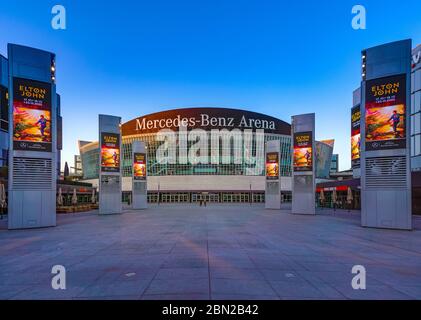 7. April 2020, die Mercedes-Benz-Arena am Mercedes-Platz in Berlin Friedrichshain am frühen Abend. Aufgrund der Koronakrise finden derzeit keine Veranstaltungen statt, so dass der Bereich um die Halle herum leer ist. Nur die Werbestelen zeigen auf den Monitoren Werbung für Konzerte von Elton John, die nicht stattfinden wird. Weltweit verwendet Stockfoto