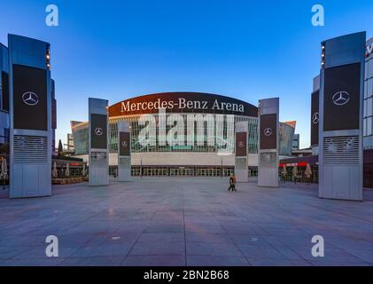 7. April 2020, die Mercedes-Benz-Arena am Mercedes-Platz in Berlin Friedrichshain am frühen Abend. Aufgrund der Koronakrise finden derzeit keine Veranstaltungen statt, so dass der Bereich um die Halle herum leer ist. Nur die Werbestelen zeigen Mercedes-Werbung auf den Monitoren. Weltweit verwendet Stockfoto