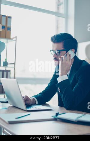 Nahaufnahme eines vertikalen Fotos von einem aufmerksamen Mitarbeiter in einer Brille, der mit Kollegen in der Geschäftswelt anruft und über ein Meeting spricht Stockfoto