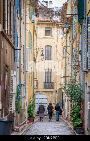 Marseille, Frankreich. Drei Frauen gehen durch eine typische enge Straße der alten französischen Küstenstadt. Stockfoto