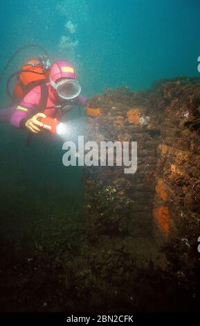 Campi Flegrei, Pozzuoli, Frühjahr 1980, Unterwasseraufnahmen der unter Wasser liegenden Ruinen des Portus Iulius. Der Hafen wurde 37 v. Chr. von Marco Vispanio Agrippa als militärische und zivile Struktur gebaut. Portus Iulius wurde im 4. Jahrhundert aufgrund der fortschreitenden Absenkung der Küstenlinie durch Bradytismus aufgegeben. Der römische Hafen wurde 1956 dank Luftaufnahmen des Militärpiloten Raimondo Bucher wiederentdeckt. Das Gebiet wird noch untersucht und vermessen. Taucher an unter Wasser getauchten Wänden. Stockfoto