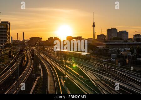 Berlin, Deutschland. Mai 2020. 06.05.2020, Berlin, Abendstimmung bei Sonnenuntergang auf den Gleisen der Berliner S-Bahn. Im Hintergrund der Berliner Fernsehturm. Blick von der Warschauer Brücke auf die Gleise, in denen sich das Sonnenlicht der untergehenden Sonne spiegelt. Kredit: dpa/Alamy Live News Stockfoto