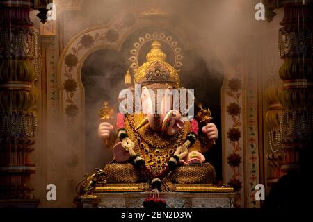 Dagdusheth Ganapati Idol in pune mit goldenem Schmuck in der Zeit der Aarti mit Rauch und schöner Dekoration im Jahr 2019 Stockfoto