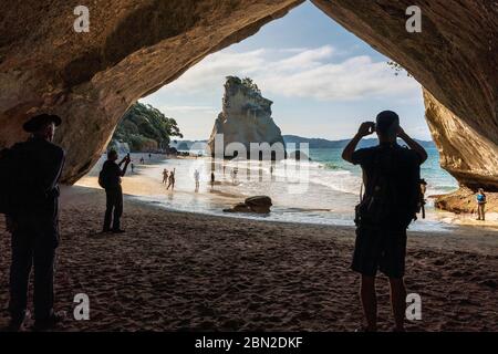 Touristen, die Fotos machen in Cathedral Cove, Coromandel Peninsula, Waikato, North Island, Neuseeland Stockfoto