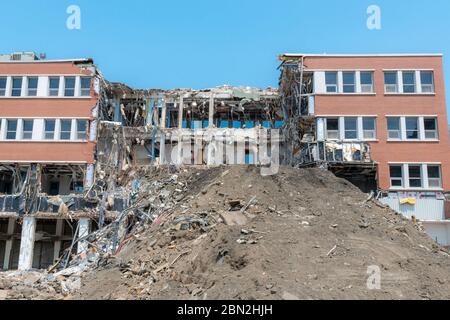 Ein teilweise abgerissen Gebäude. Ein Großteil der Mitte des Gebäudes fehlt, und es gibt einen großen Haufen Schmutz vor. Viel Schmutz und hängend Stockfoto