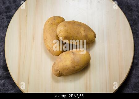 Frische Kartoffel auf hölzerne Tabellenhintergrund, Konzept und Idee von Essen kochen rustikalen noch Life-Style. Dramatische Licht Tischdekoration. Stockfoto