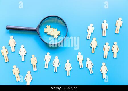 Geschäftsbild der Lupe mit Menschen-Symbol auf blauem Hintergrund, Aufbau eines starken Teams, Personal und Management-Konzept. Puzzles Stockfoto