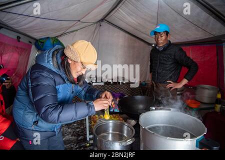 (200512) -- BASISLAGER QOMOLANGMA, 12. Mai 2020 (Xinhua) -- EIN Koch kocht im Vorlager auf 6,500 Metern Höhe auf dem Berg Qomolangma, 10. Mai 2020. Das Vorlager liegt auf einem Hang am Ende des East Rongbuk Gletschers und ist das letzte Lager vor der Schneelinie und der Eis- und Schneestraße auf dem Mount Qomolangma. Auch als "Lager der Bösen" bekannt, leiden viele der professionellen Bergführer, die den Gipfel des Mount Qomolangma unzählige Male erreicht haben, aufgrund ihrer geographischen Lage an Höhenkrankheit. Es ist ein Gebiet umgeben von Bergen und schlechter Luftzirkulation. ( Stockfoto