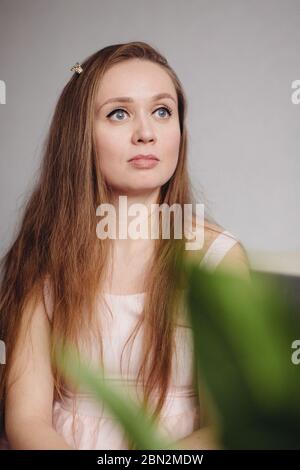 Nahaufnahme Porträt der natürlichen ruhigen nachdenklichen Frau mit grauen Augen und Licht Make-up, Blick weg, trägt kleine Krone Schmuck Stockfoto