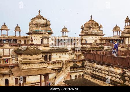 Orchha, Madhya Pradesh, Indien: Eine indische Frau in einem blauen Sari steht an einem der Balkone des eindrucksvollen 17. Jahrhunderts Jahangir Mahal Palastwit Stockfoto