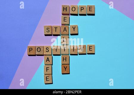 Positiv, gesund, Bleiben, sicher, Hoffnung, Kreuzworträtsel auf blau und lila isoliert Stockfoto
