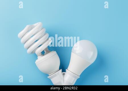LED-Glühbirne und Energieeinsparung in einem doppelten Sockel auf blauem Hintergrund. Die Aussicht von oben Stockfoto